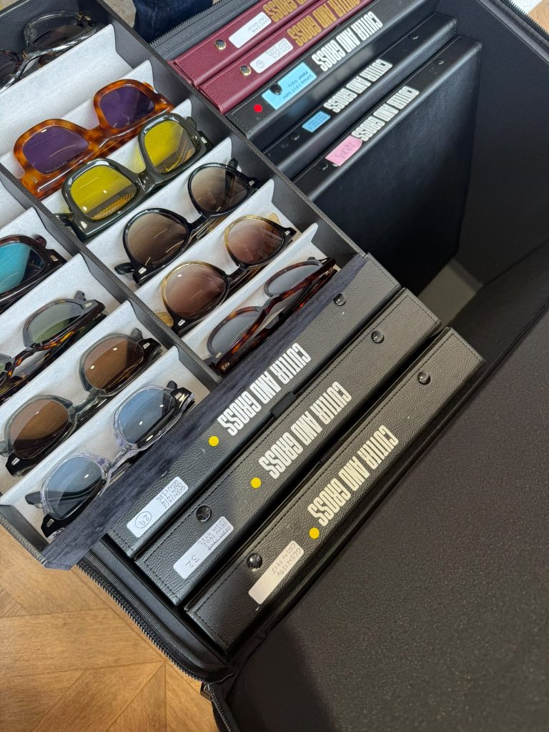 Selection of Cutler and Gross designer sunglasses displayed in organised travel cases, showcasing a variety of handcrafted acetate frames and tinted lenses for an exclusive eyewear styling consultation.