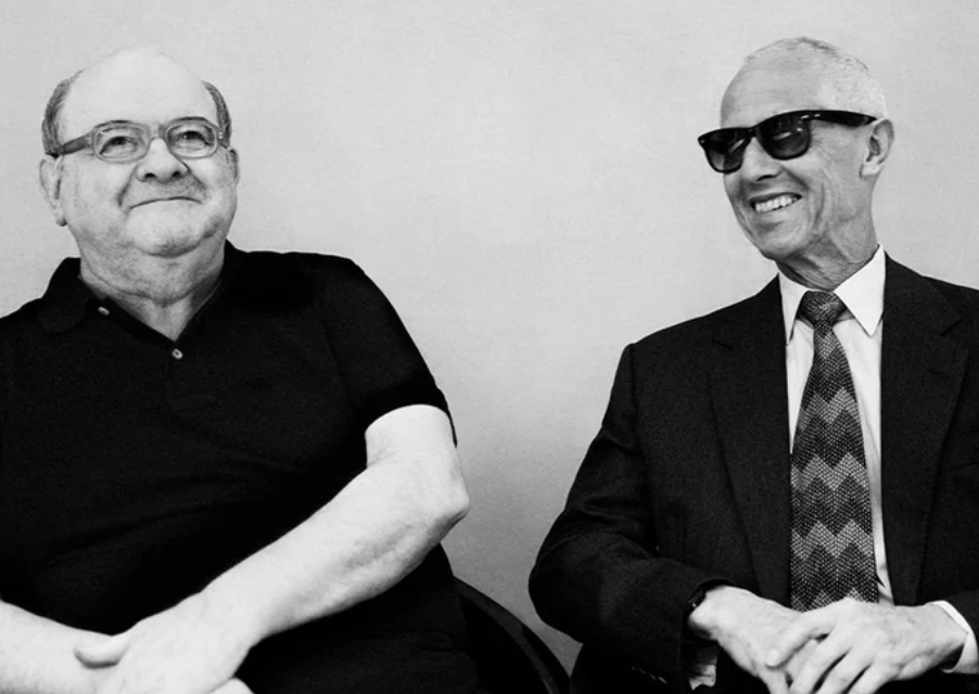 Black-and-white portrait of Cutler and Gross founders Tony Cutler and Graham Cutler, seated together wearing distinctive eyewear that reflects the brand's iconic British design heritage.