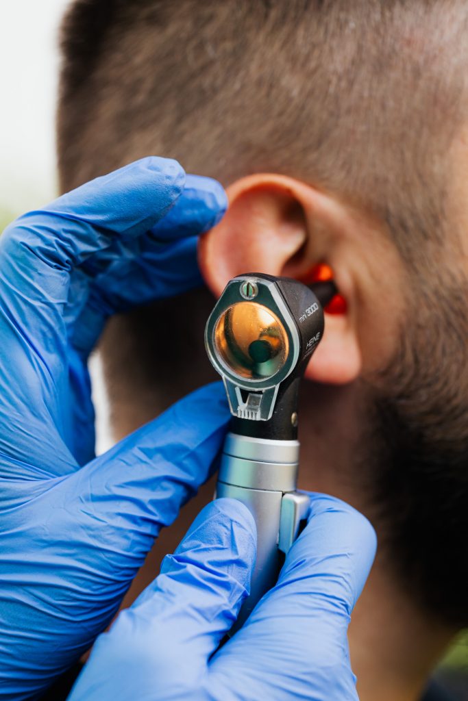 Clinician examining a patient's ear with an otoscope during a professional hearing check at Edwards & Walker Opticians in Doncaster